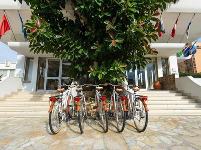 Fahrräder vor einem Hoteleingang mit Treppen und großen Pflanzen.