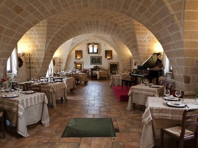 Restaurant mit gewölbten Steinbögen, gedeckten Tischen und warmem, rustikalem Ambiente.
