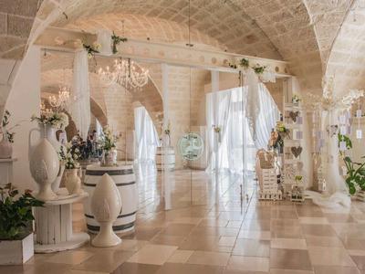 Heller, eleganter Saal mit gewölbten Decken, Marmorboden, dekorativen Säulen und Pflanzen.