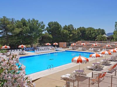 Freizeitpool mit Liegestühlen und Orangenschirmen an einem sonnigen Tag.