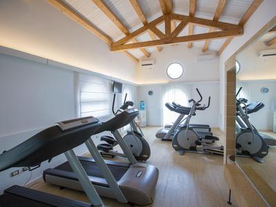 Siłownia z bieżniami i rowerami, drewniany sufit i ściana z lustrem