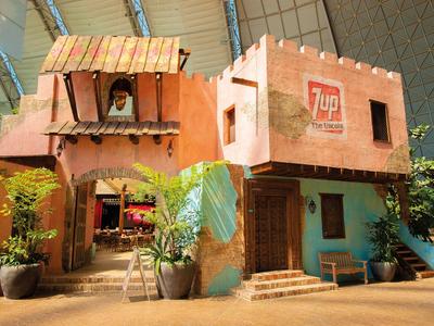 Buntes zweistöckiges Gebäude mit Pflanzen vor dem Eingang in sonniger Umgebung