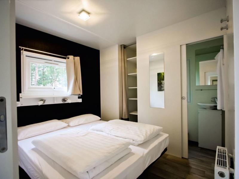 Cozy hotel room with double bed, window, and adjoining bathroom.