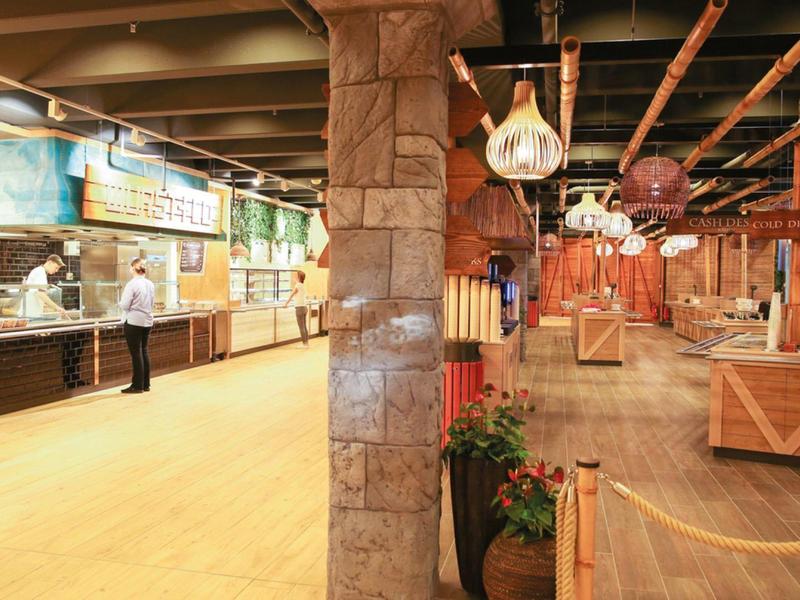 Rustic interior of a restaurant with wooden paneling and buffet stations.