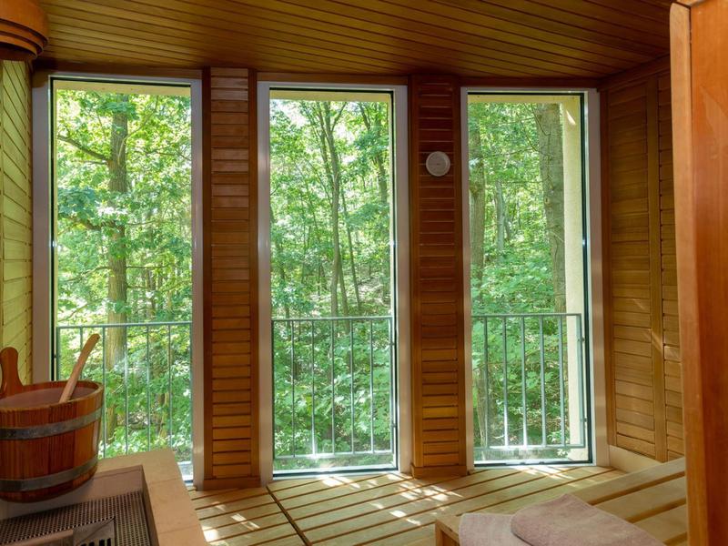 Stanza sauna con grandi finestre che si affacciano su alberi verdi