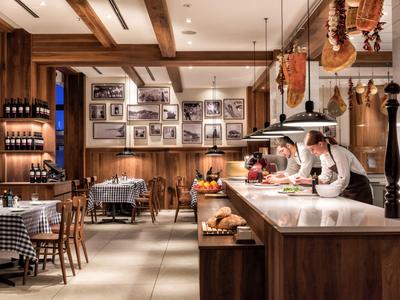 Gemütliches Restaurant mit Holzmöbeln, Weinregal und dekorativen Fotos an der Wand.