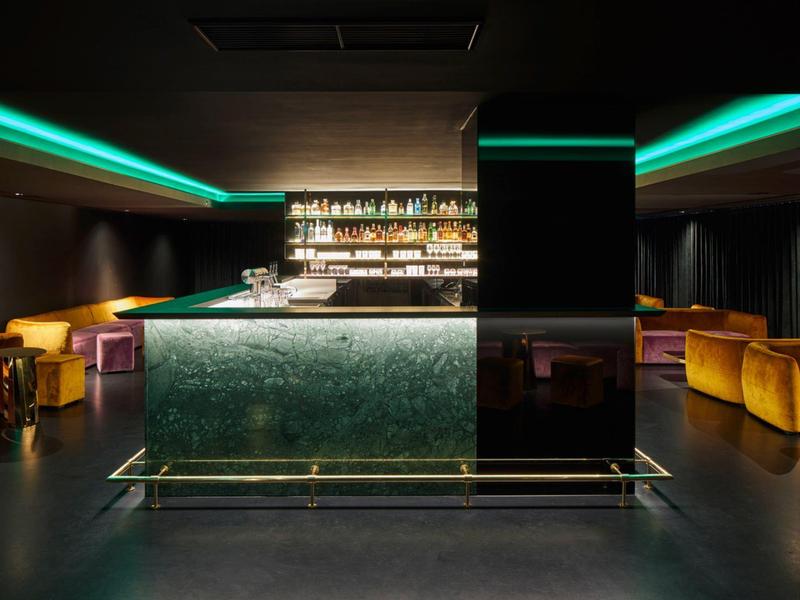 Bar d'hôtel moderne avec intérieur sombre et éclairage LED vert