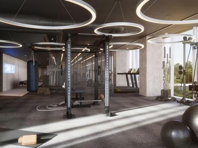 Moderner Fitnessraum mit Zirkeltrainingsgeräten, Hantelbänken und großen Fenstern mit Außenausblick.