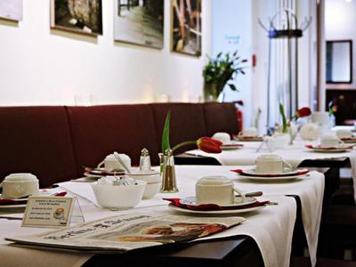 Elegantes Restaurantinterieur mit weiß gedeckten Tischen und braunen Sitzbänken.