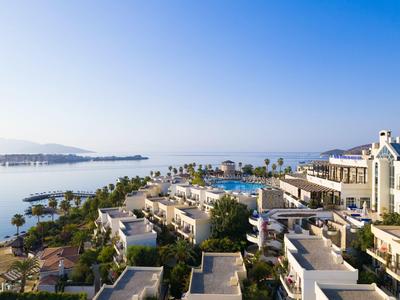 Luxe hotelresort met zwembad aan zee onder heldere blauwe lucht