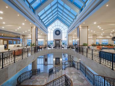 Ruime, lichte hotel lobby met moderne architectuur en veel natuurlijk licht.
