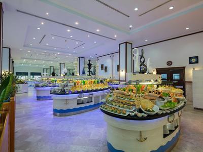 Grote, lichte hotelbuffetruimte met een brede selectie fruit en gerechten.