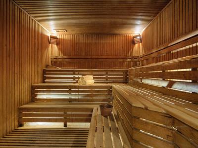 Interieur van een sauna met verhoogde houten banken en warme verlichting.