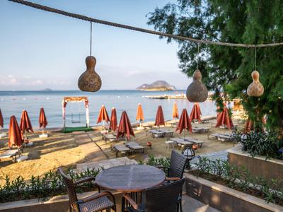 Restauracja na plaży z parasolami i stolikami z widokiem na małe wyspy