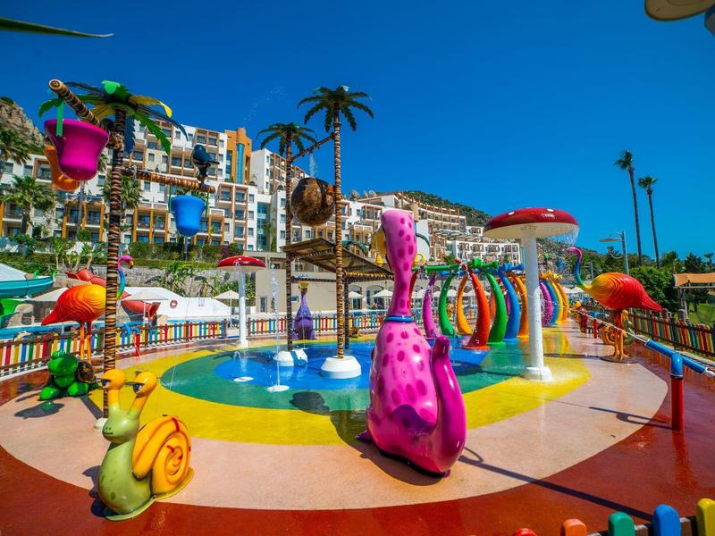 Kolorowy plac zabaw wodnych z zabawnymi figurami i fontannami pod czystym niebem.