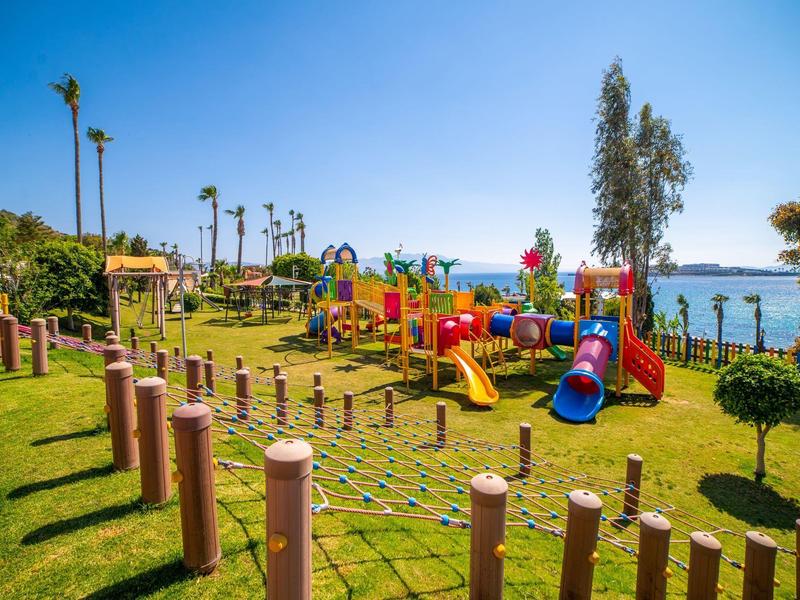 Plac zabaw z kolorowym wyposażeniem i widokiem na morze pod czystym niebem.