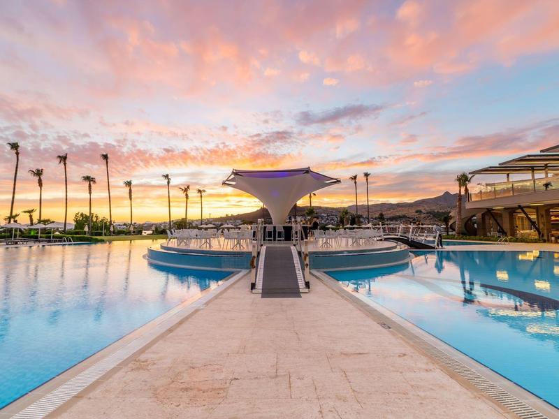 Nowoczesny basen z elegancką architekturą i palmami o zachodzie słońca