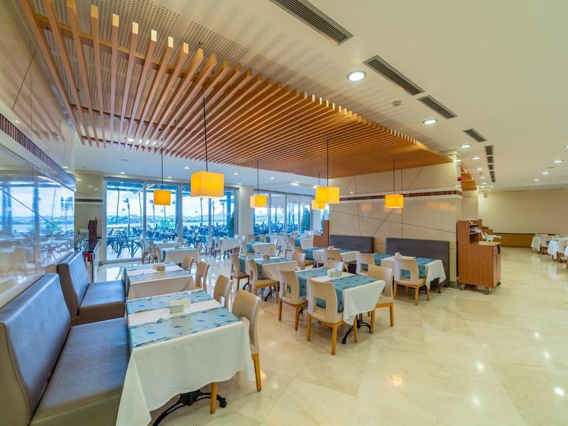 Nowoczesna restauracja z nakrytymi stołami, brązowymi krzesłami i dużymi oknami z widokiem.