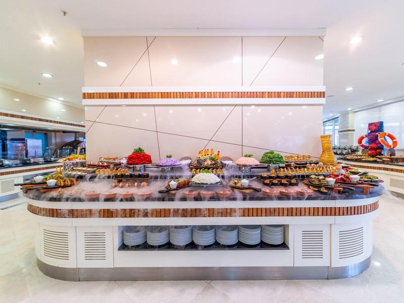 Bufet z różnorodnym jedzeniem i świeżymi składnikami w nowoczesnej, dobrze oświetlonej restauracji hotelowej.