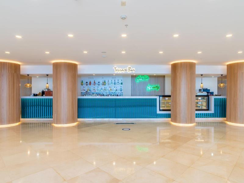 Nowoczesny bar hotelowy z niebieskim konturem i czterema okrągłymi kolumnami