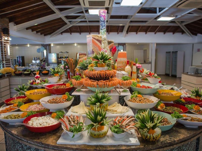 Luxe buffet met tropisch fruit en kleurrijke gerechten in een lichte eetzaal.