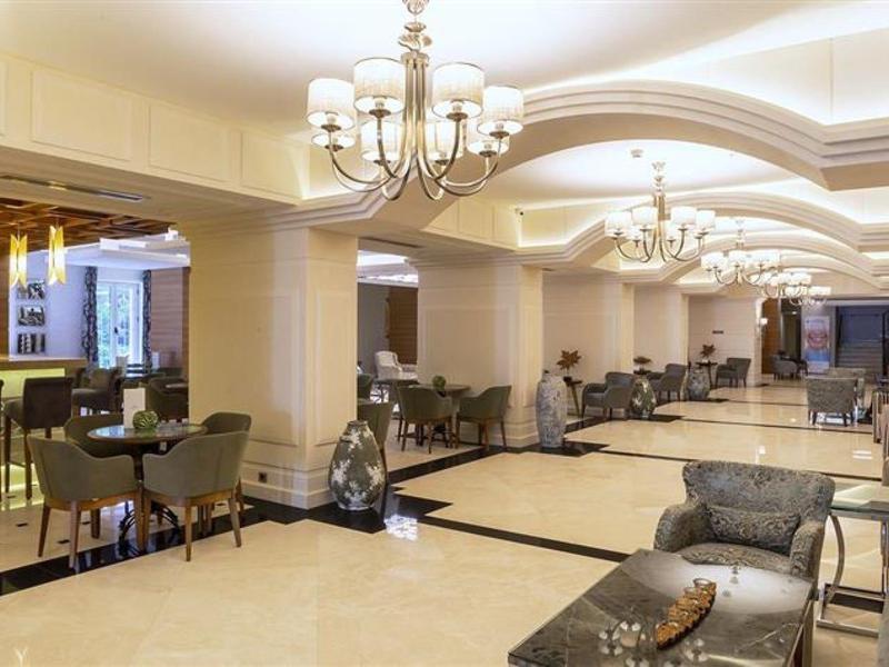 Elegante hotel lobby met bar, gezellige zitgedeeltes en kroonluchters.