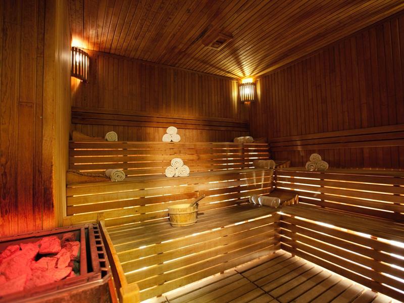 Houtsauna met meerlaagse banken en zachte verlichting in een hotel
