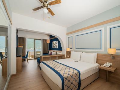 Modern eingerichtetes Hotelzimmer mit großem Bett, Schreibtisch und Meerblick.