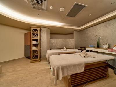 Sala de spa moderna con dos camillas de masaje y luz relajante