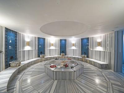 Zona de spa moderna con superficie redonda de mármol y luz suave