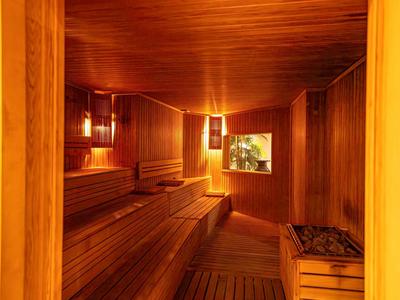 Sauna acogedora con revestimiento de madera y luz cálida para momentos relajantes de vacaciones.