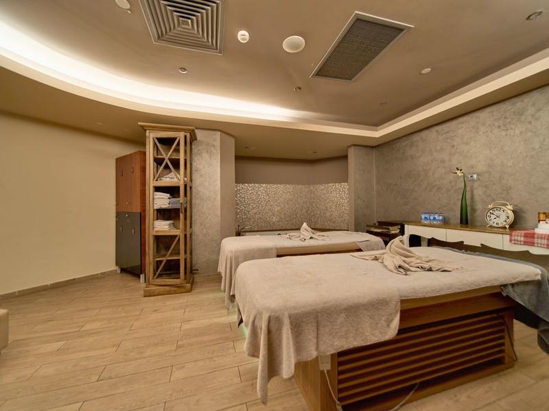 Sala de spa moderna con dos camillas de masaje y luz relajante