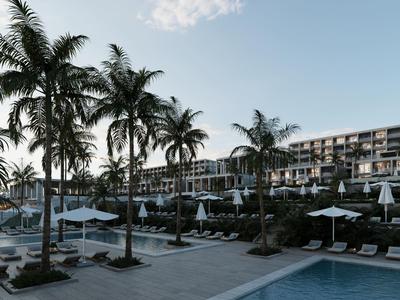 Modern hotelcomplex met zwembad, palmbomen en ligstoelen bij een heldere hemel.