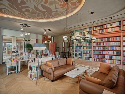 Moderner Hotellounge-Bereich mit Ledersofas, Bücherregalen und stilvoller Deckenbeleuchtung.