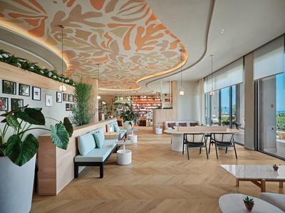 Modernes Hotelinnendesign mit Sitzbereichen, großen Fenstern und Deckenkunst.