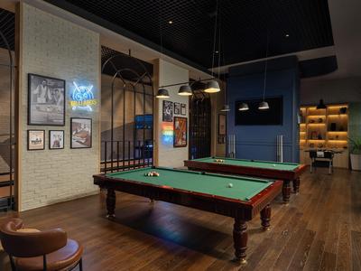 Eleganter Spielbereich mit zwei Billardtischen und gemütlicher Beleuchtung in einem Hotel.