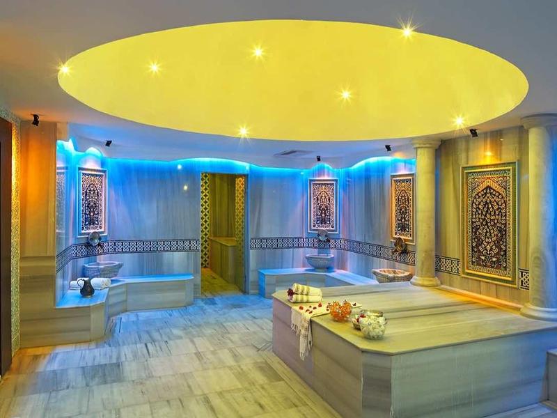 Luxuriöser Wellnessbereich mit gedämpftem Licht, Marmorbecken und dekorativen Wandpaneelen.