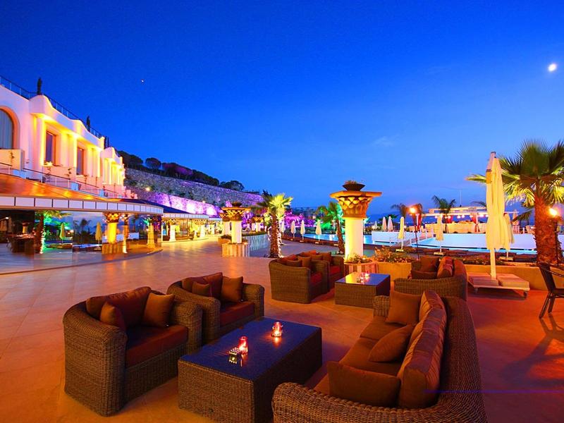 Gemütliche Sitzgruppe mit braunen Polstermöbeln auf Terrasse bei Abenddämmerung und blauem Himmel.
