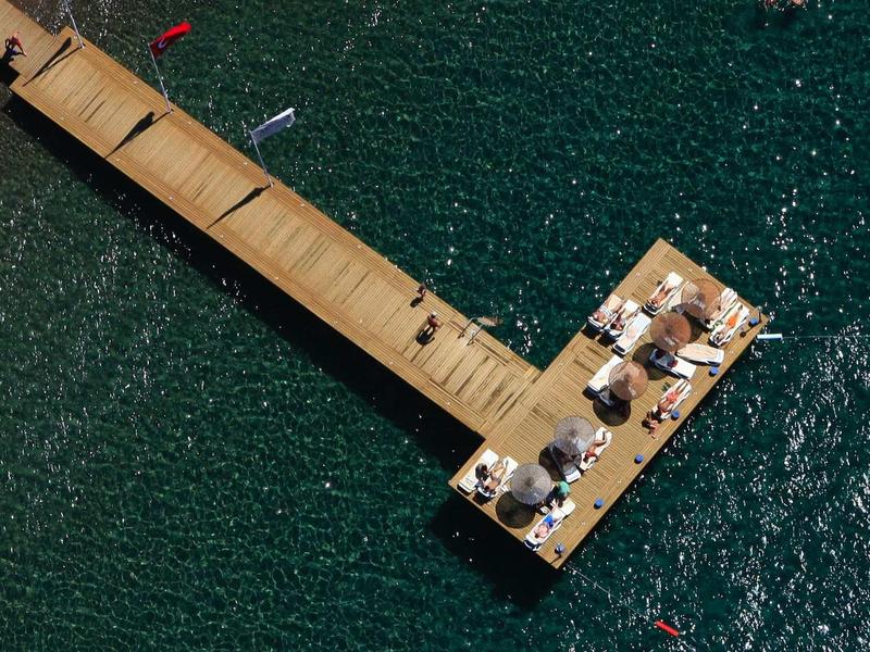 Long pier with seating and umbrellas over clear water