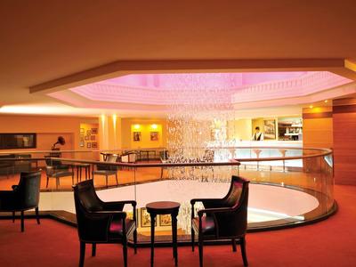 Elegant hotel lounge area with circular railing and central lighting.