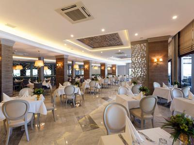 Elegant hotel restaurant with white tablecloths, soft lighting, and modern wooden details.