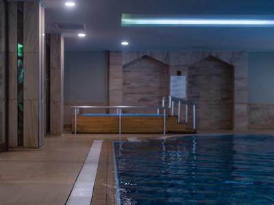 Modern indoor pool with clear water and wooden details on the walls