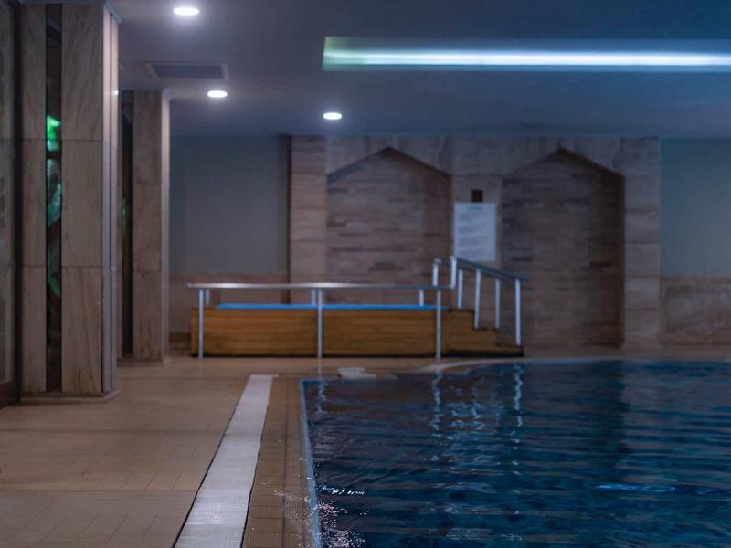 Modern indoor pool with clear water and wooden details on the walls