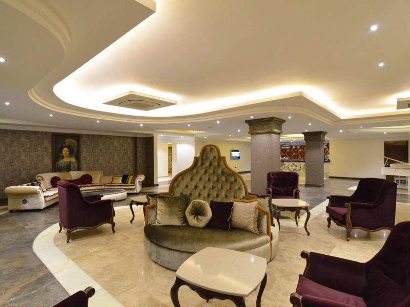 Eleganter Hotel-Lounge mit runden Polstersesseln, Teppichboden und indirekter Deckenbeleuchtung.