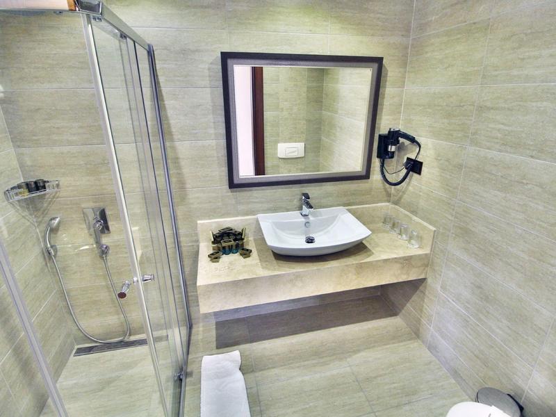 Moderne kleine Badezimmer mit Walk-In-Dusche, rechteckigem Waschbecken, großem Spiegel und Föhnhalterung.