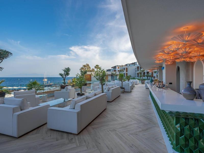 Elegancki taras hotelu z białymi fotelami i widokiem na morze