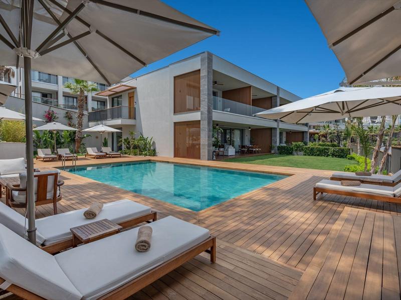 Basen na zewnątrz otoczony leżakami i parasolami w nowoczesnym hotelu.