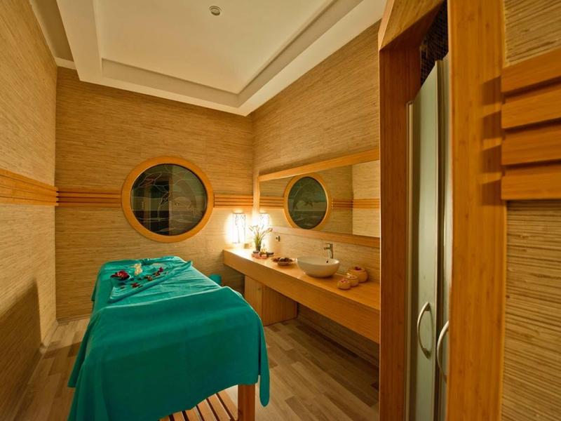 Una sala de tratamiento tranquila con una camilla y decoración cálida de madera para bienestar.