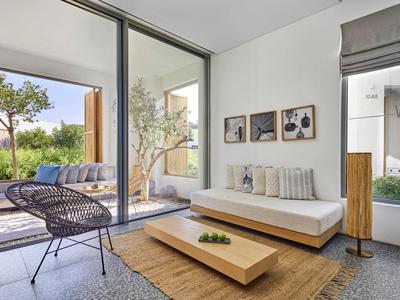 Modern living area with sofa, wooden coffee table, chairs, and access to terrace with garden view.