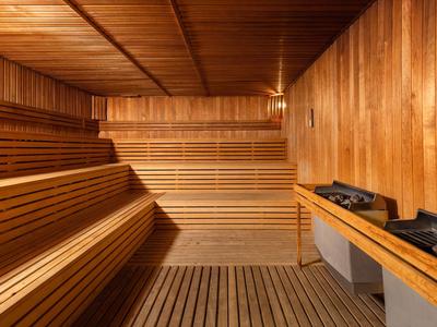 Cozy sauna with wooden paneling and multi-level seating benches.